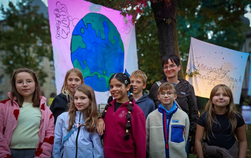 Schülerinnen und Schüler der Erich Ohser Grundschule mit Leiterin Susann Thoß vor ihrem gestalteten Transparent. Foto: T. Voigt